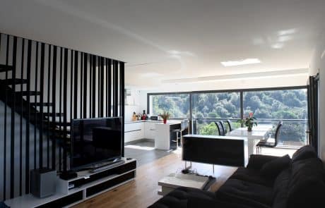 casa-prefabricada-sala-estar-01 Sala de estar con escalera y vistas al paisaje